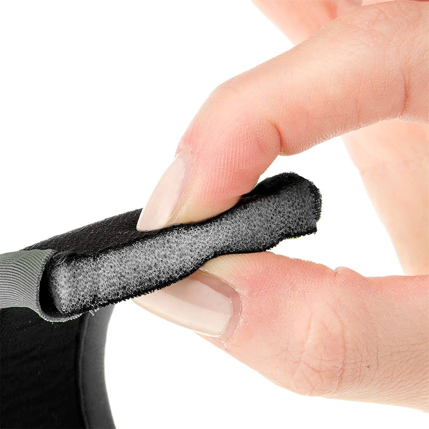 Dubbelklikken om te vergroten Close-up van een hand die knijpt in de grijze schuimvulling met zwarte stoffen bekleding van het Ergotrekking hondentuig, zwart, XS.