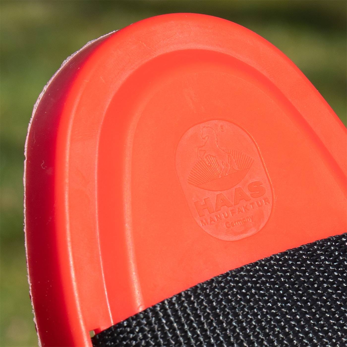 Close-up van de HAAS eg New Generation voor paarden en pony's van Haas, met een rode kunststof behuizing met het HAAS MANUFAKTUR-logo.