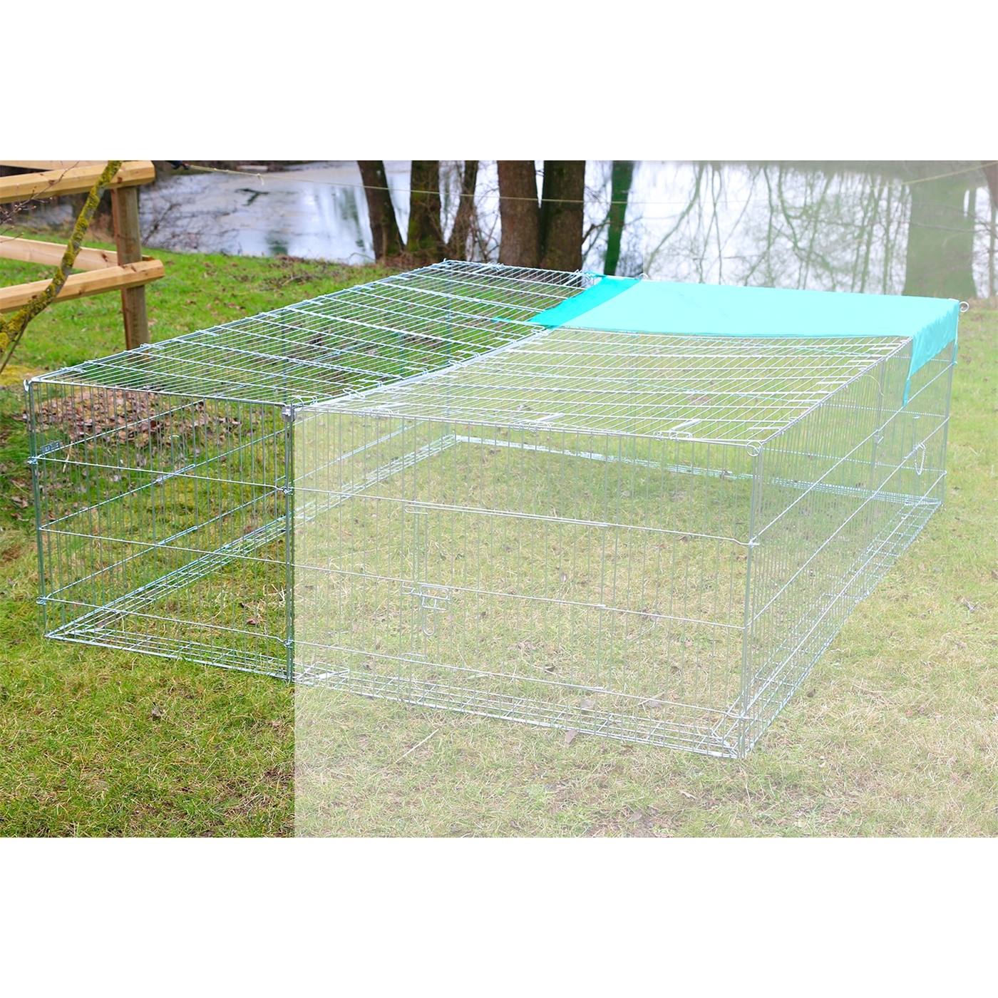 Twee uitbreidingselementen voor vrijloopleefruimten met ontsnappingsbarrières van metaaldraad met een blauwe afdekking worden op gras in de buurt van bomen en water geplaatst.