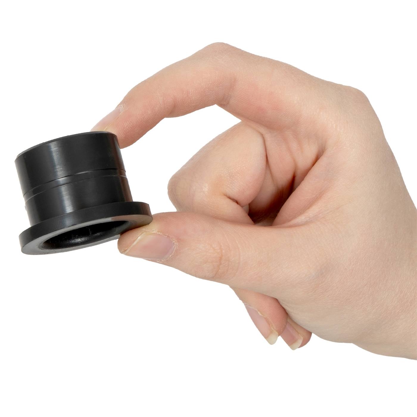 Eén hand houdt tussen duim en wijsvinger een Lister klepbus voor L3 en L4 weidepomp, een klein zwart cilindervormig plastic onderdeel van Lister.